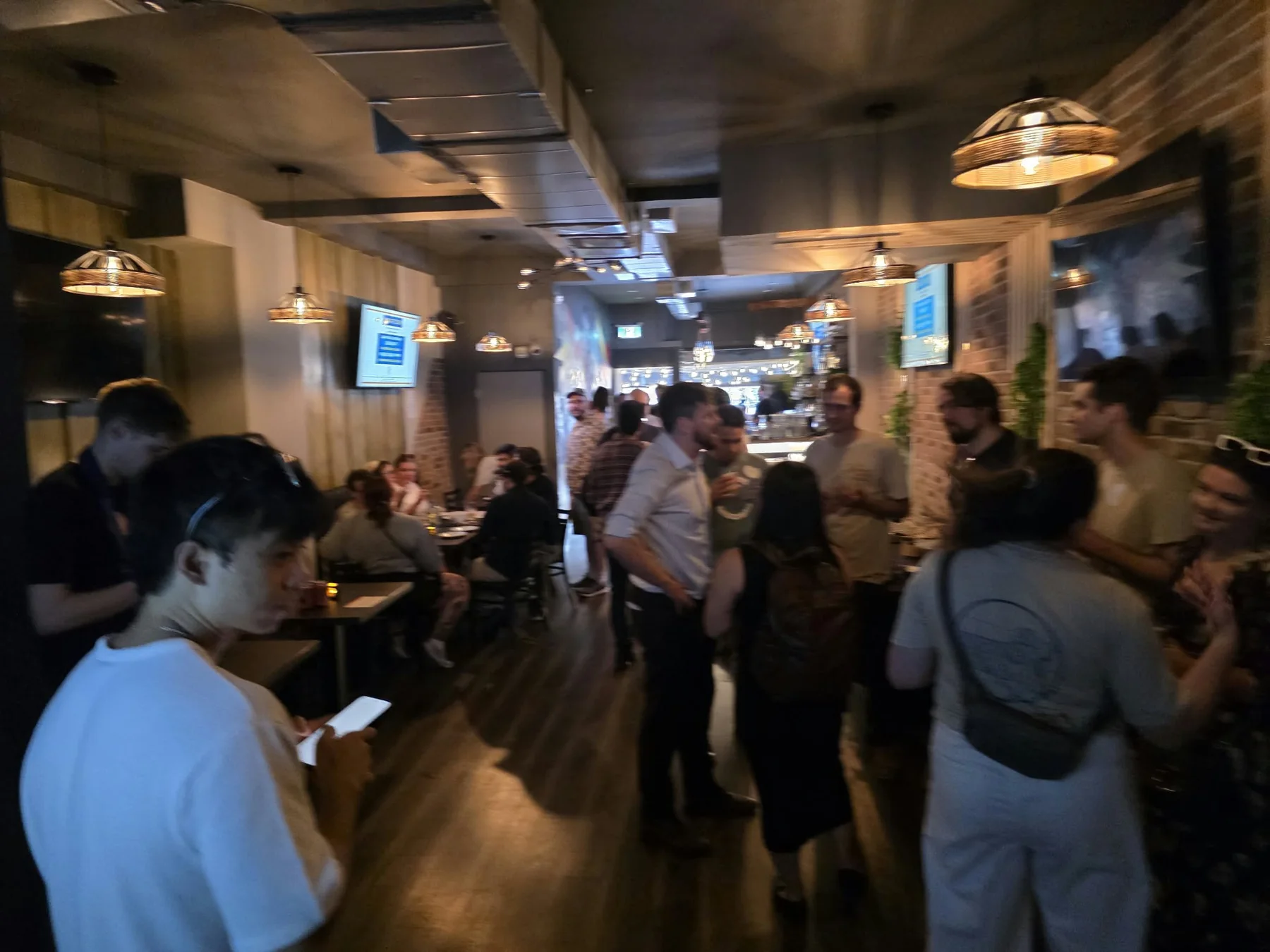A lively crowd gathering around the Kensington Socials bar