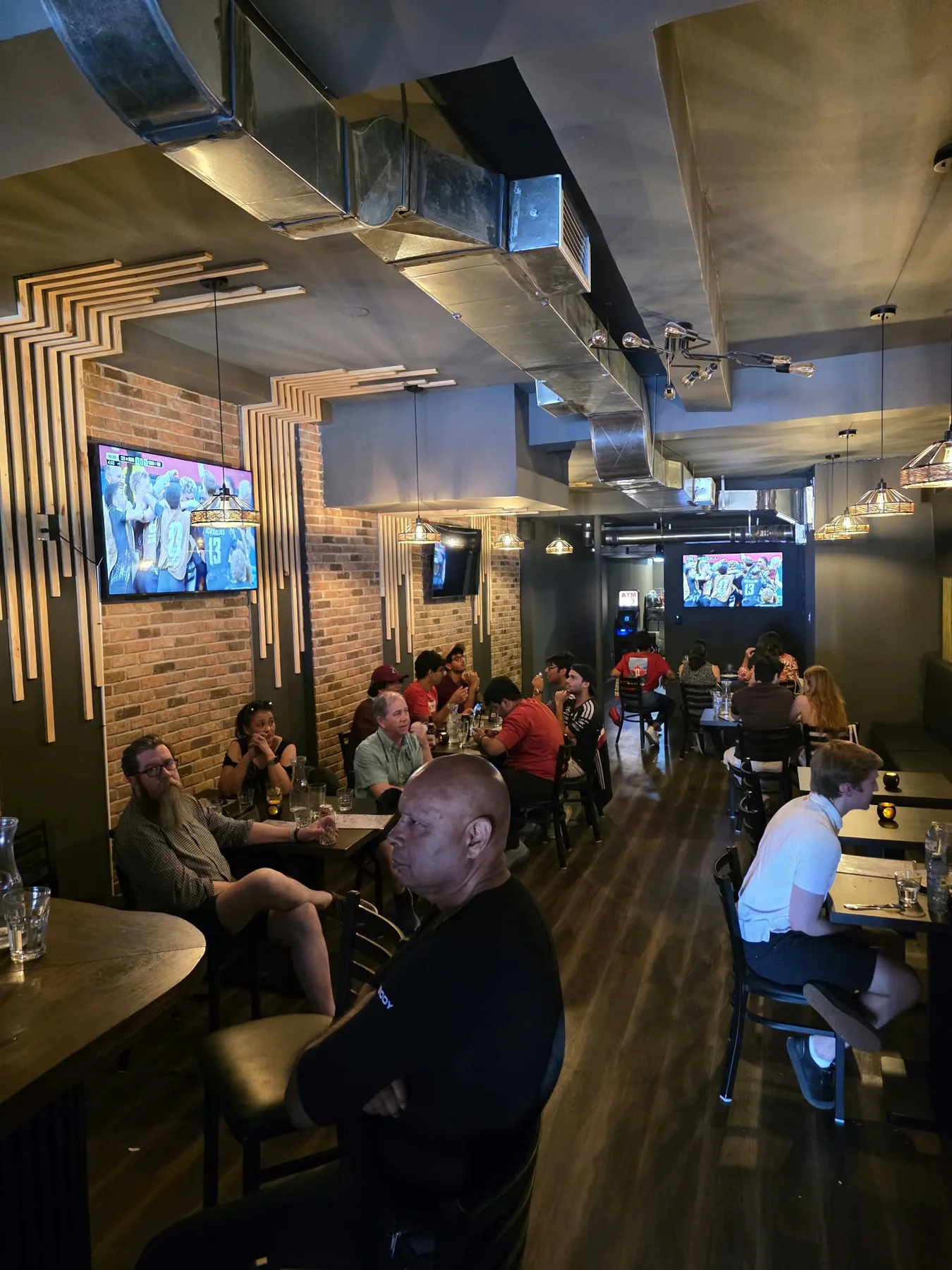 Guests watching sports on screens at Kensington Socials